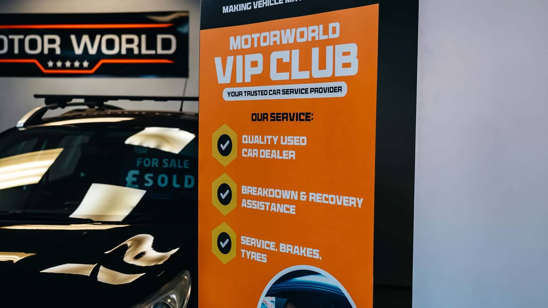 MotorWorld branded vertical banner inside the workshop where EV servicing is carried out