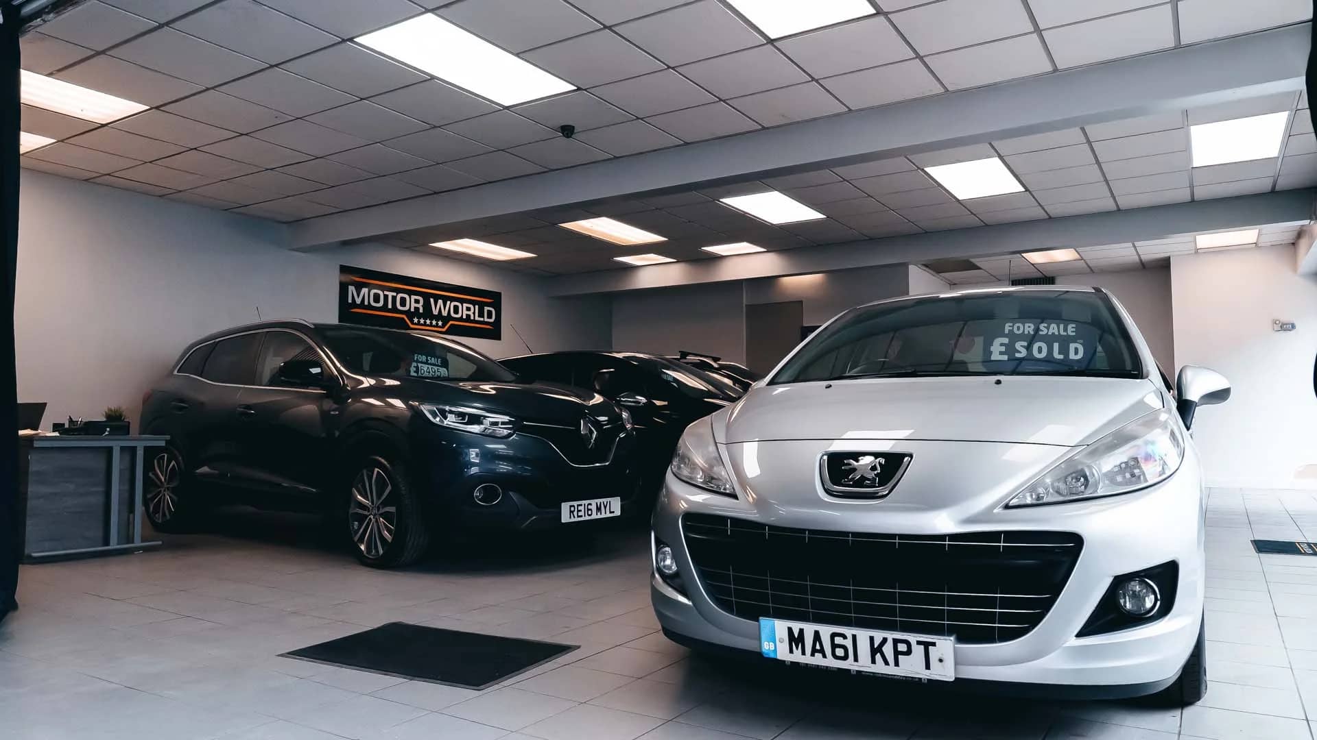 Low-angle shot of the MotorWorld showroom with used cars on display