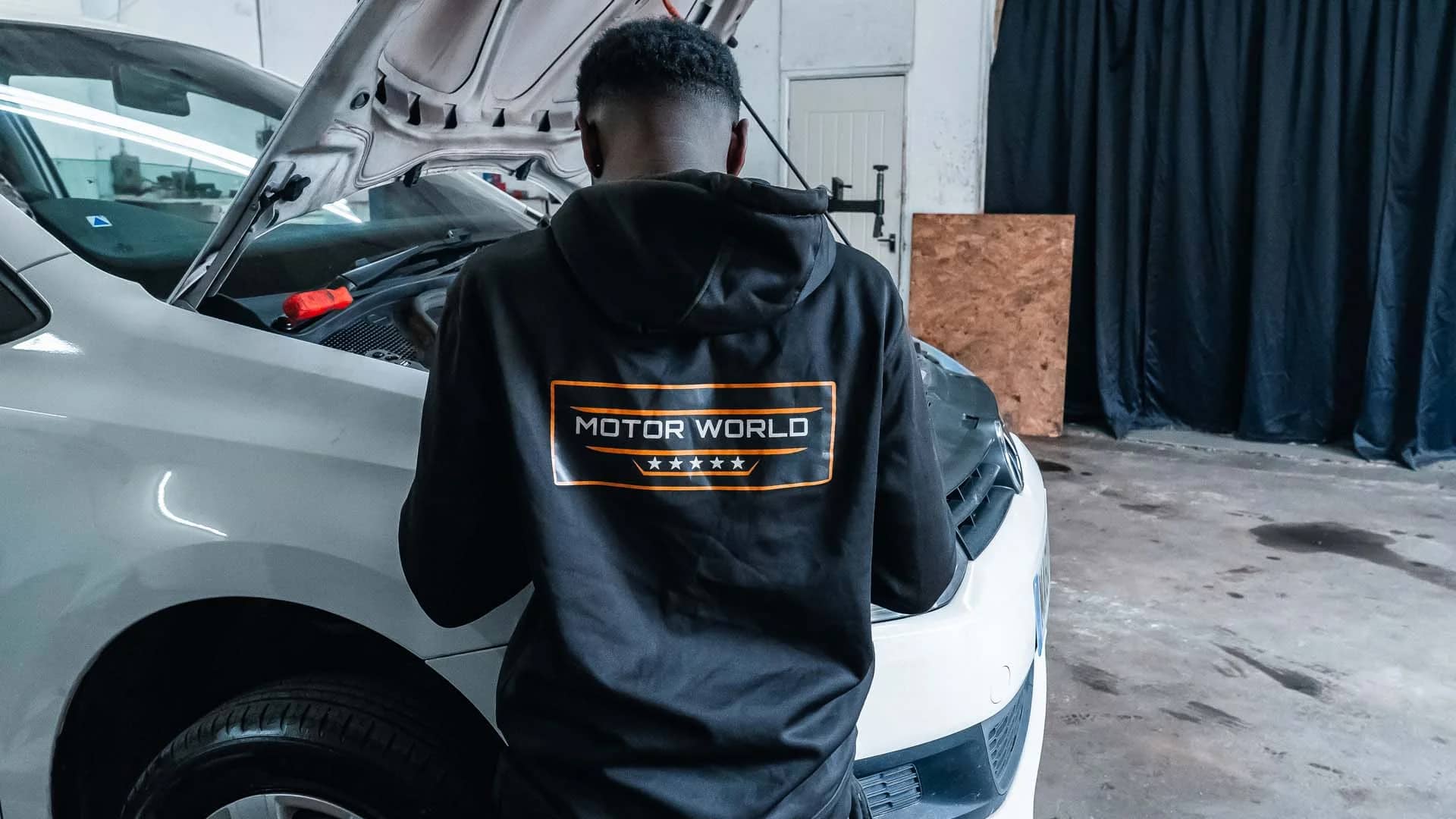 MotorWorld technician working on a car with the bonnet open